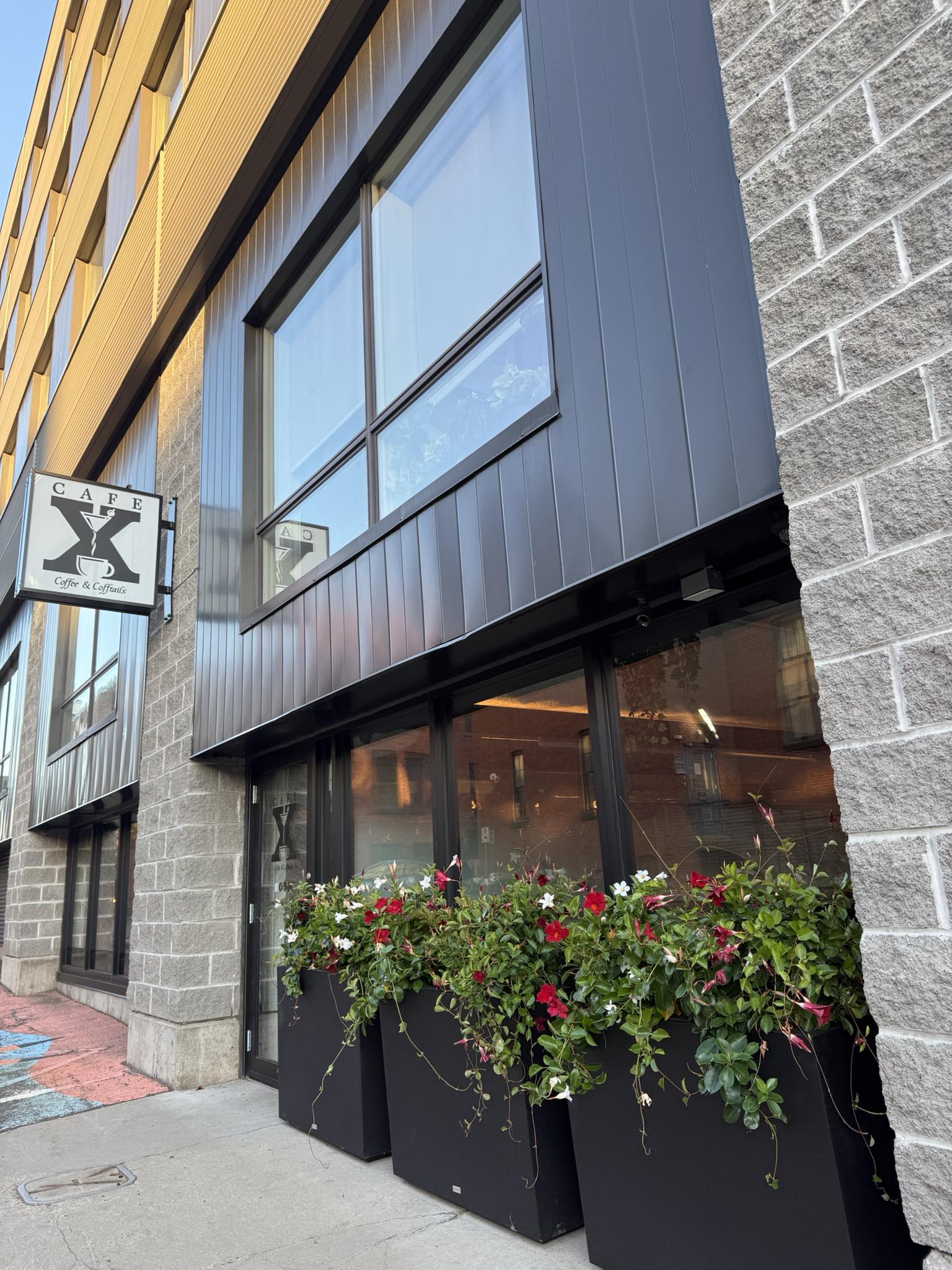 Cafe X storefront with sign and flowers